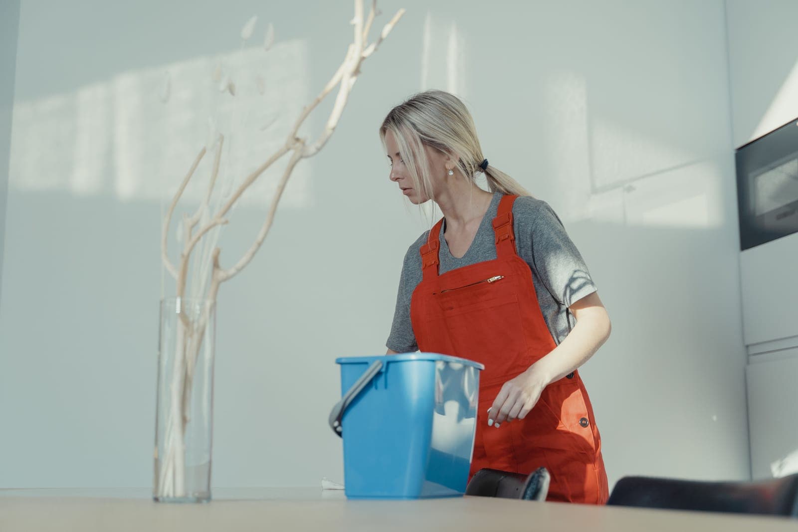 Reinigungskraft mit Eimer bei der Arbeit