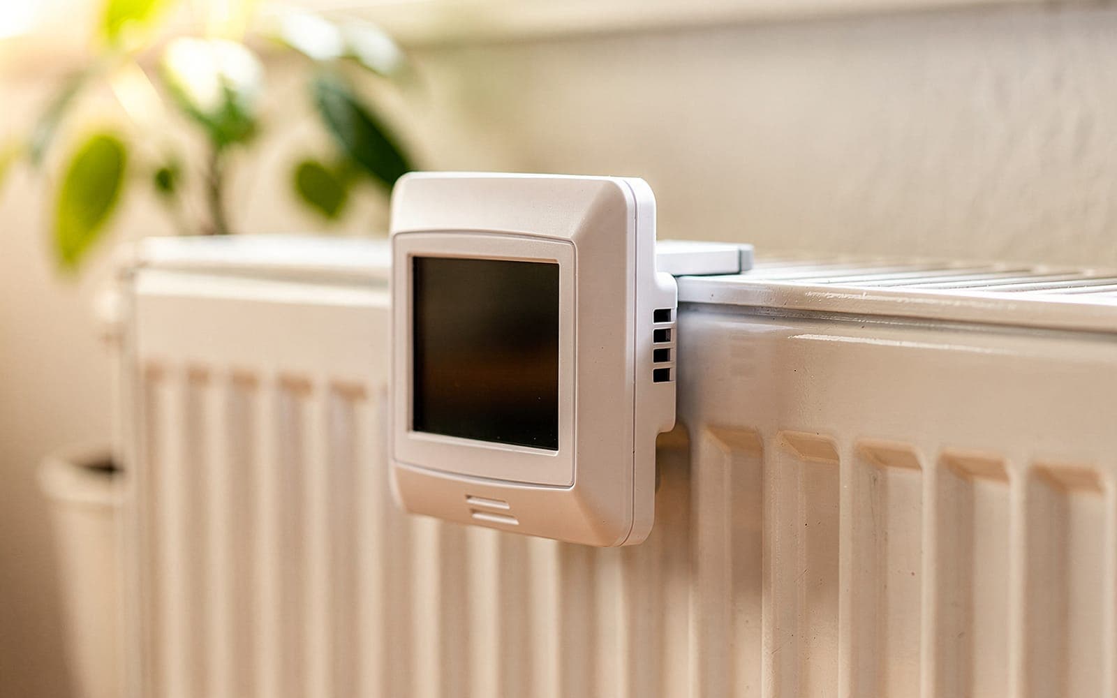 Elektronischer Heizkostenverteiler am Heizkörper im hellen Wohnzimmer
