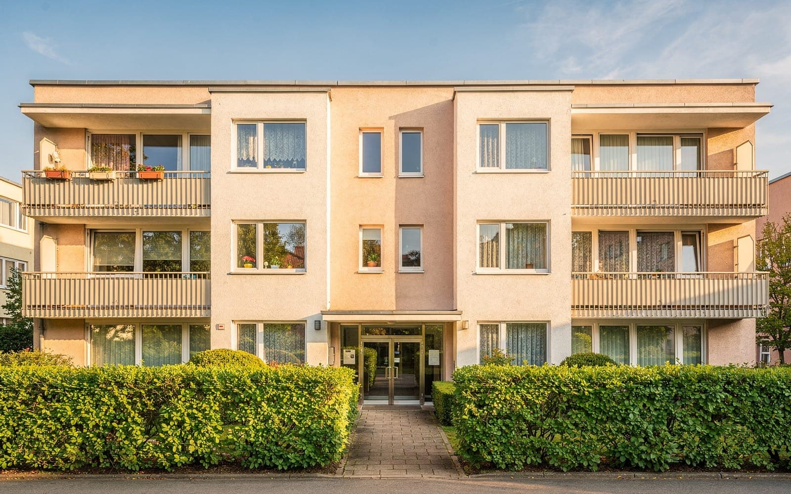 Mehrfamilienhaus aus den 70er-Jahren an einem sonnigen Tag